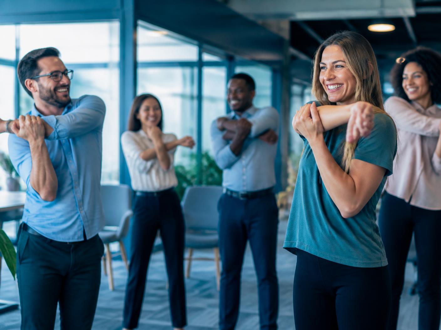Collega's doen een vitaliteitsworkshop op kantoor